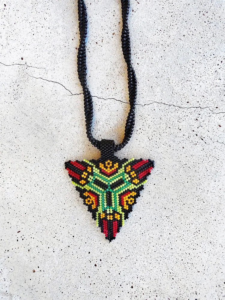 Handmade geometric triangle pendant necklace featuring handwoven herringbone and peyote stitch nonmetal beaded chain in black, green, yellow, and red.