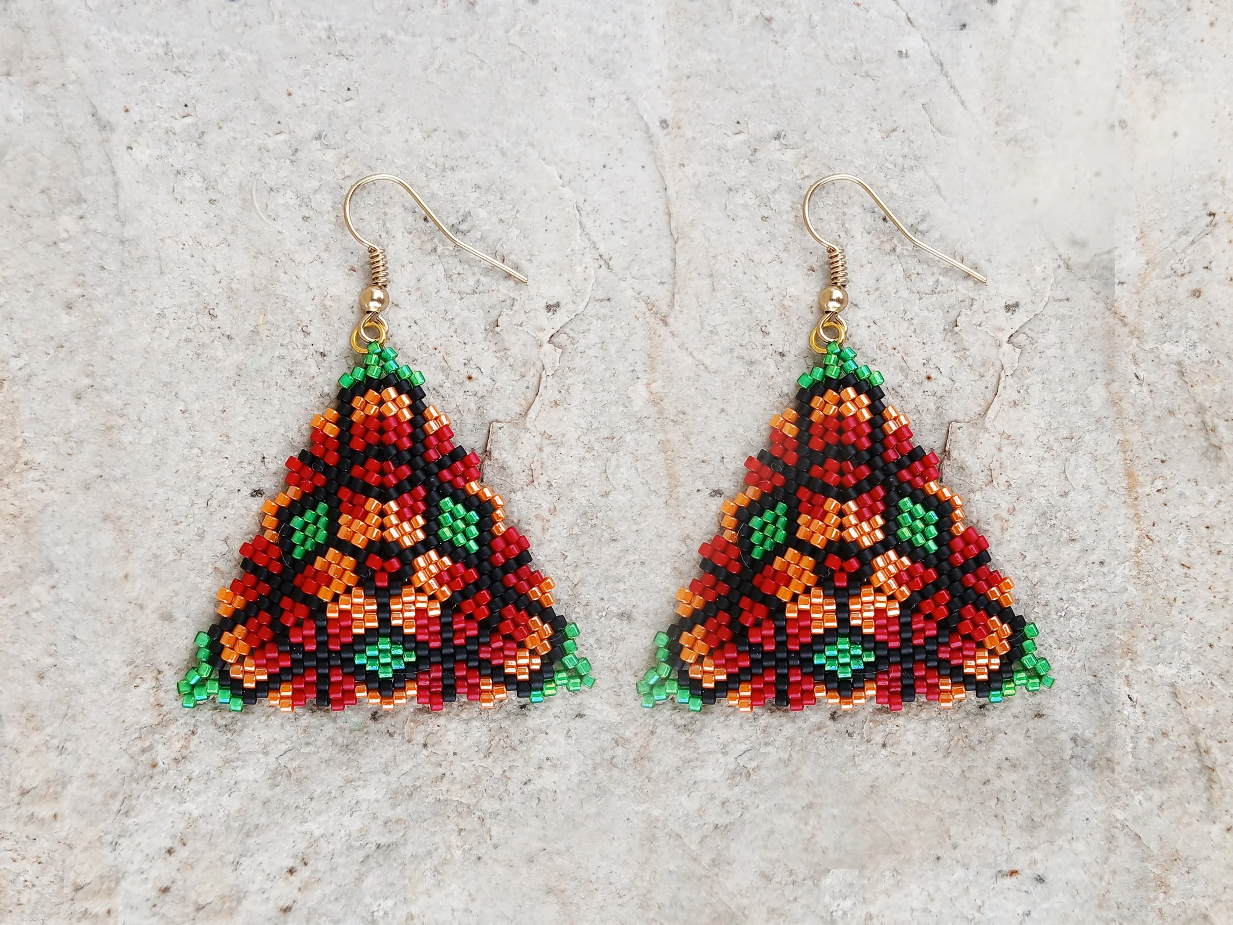 Handmade triangle peyote earrings with geometric floral pattern in red, green, orange, and black Miyuki Delica glass beads