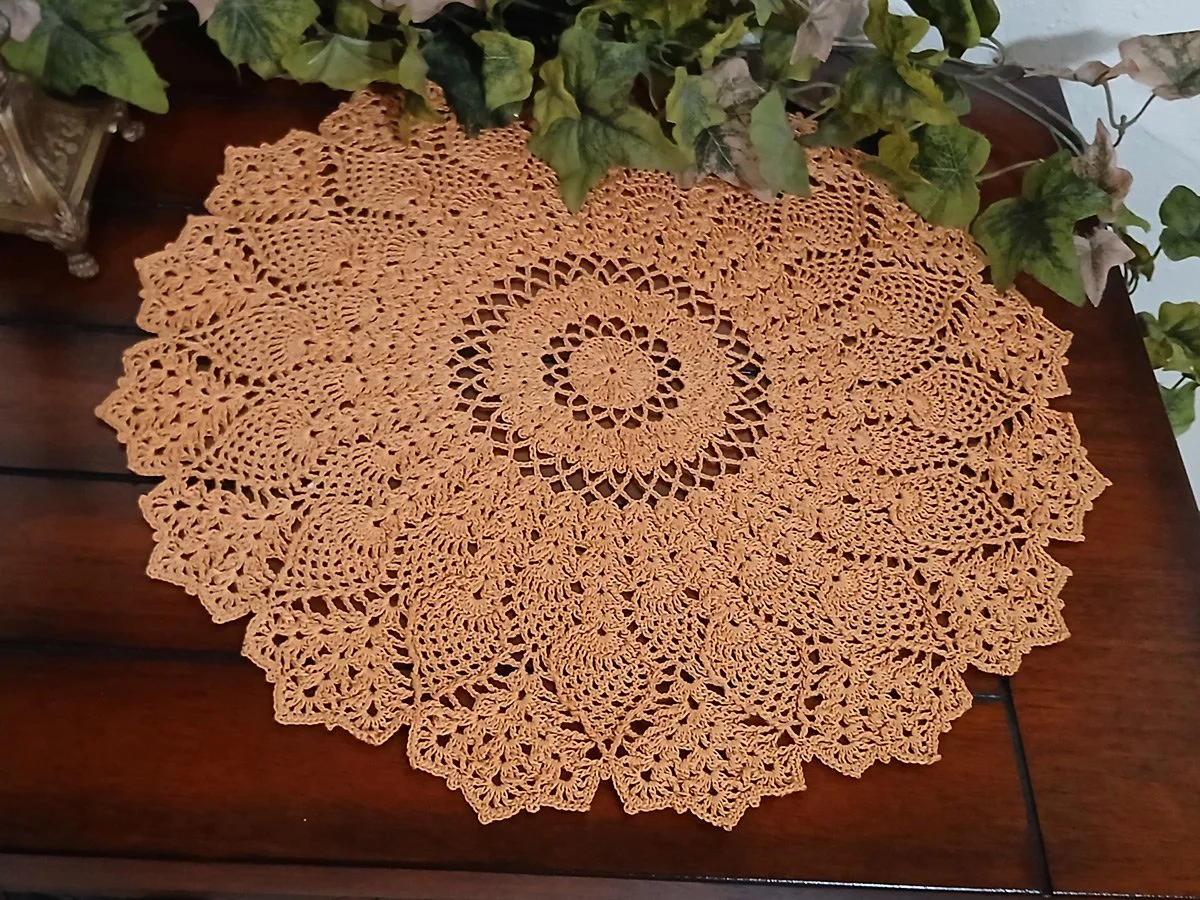 Exquisite and highly detailed 17-inch round crochet lace doily handwoven in a warm topaz color with a dimensional pineapple pattern