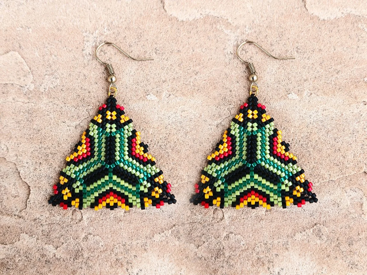 Handmade southwestern geometric triangle peyote beaded dangle earrings featuring a handwoven in green, red, black, and orange color palette.