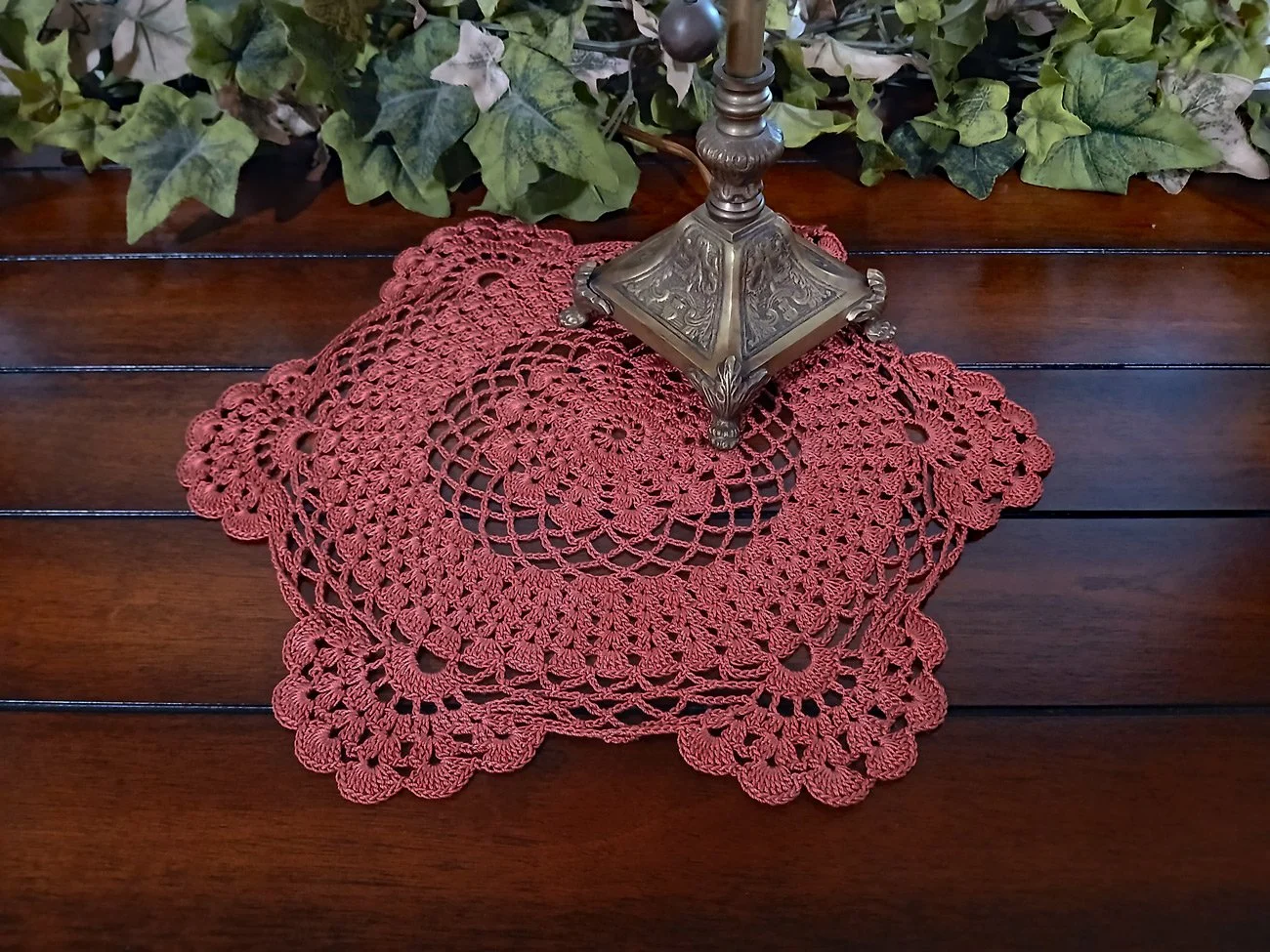 Handmade 13-inch round crochet lace doily in a rich rust orange color featuring intricate scalloped edges and pointed details