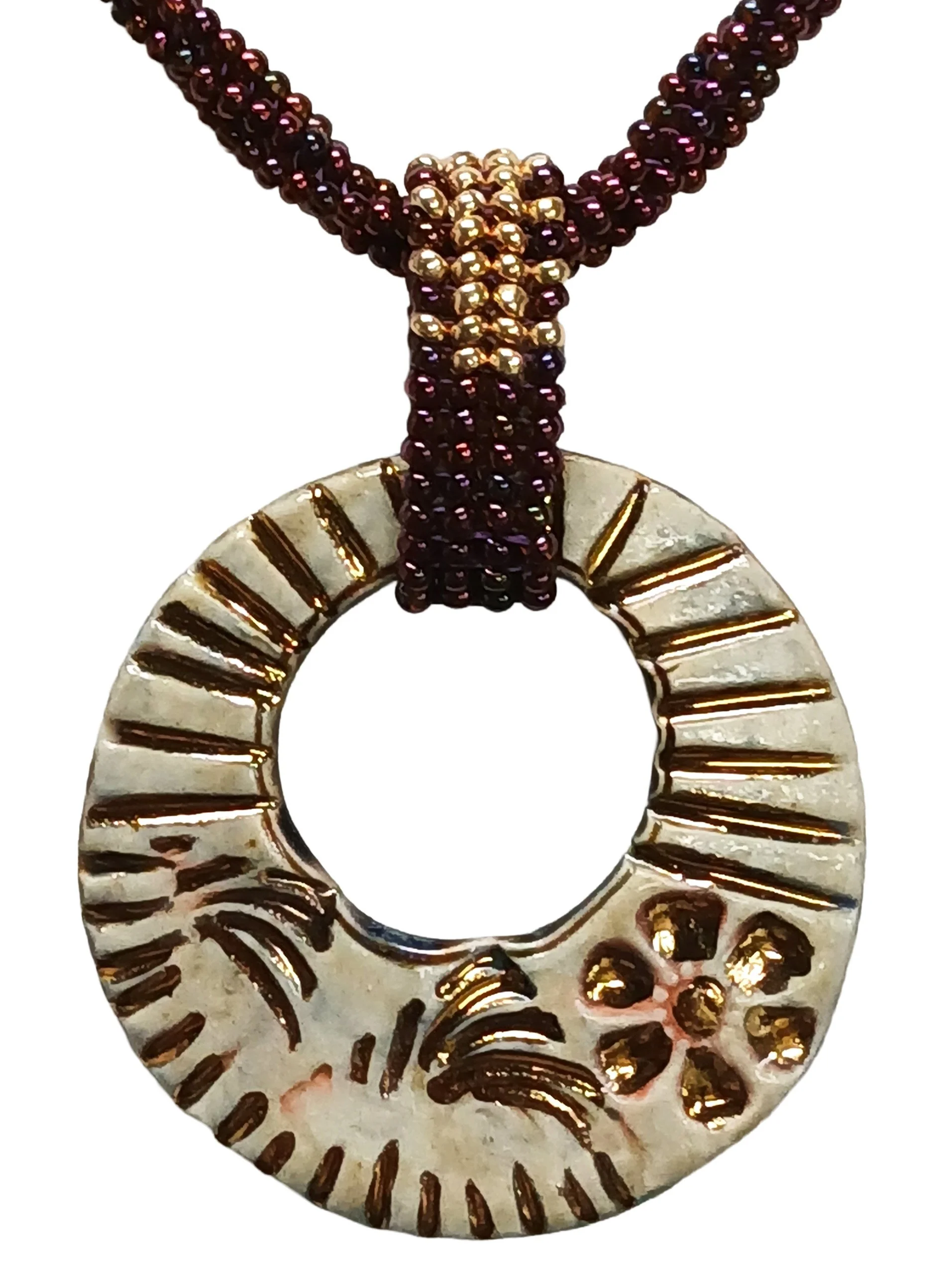 Handmade non-metal beaded rope necklace with open round pendant handwoven in metallic iris rose and gold accents and toggle clasp.