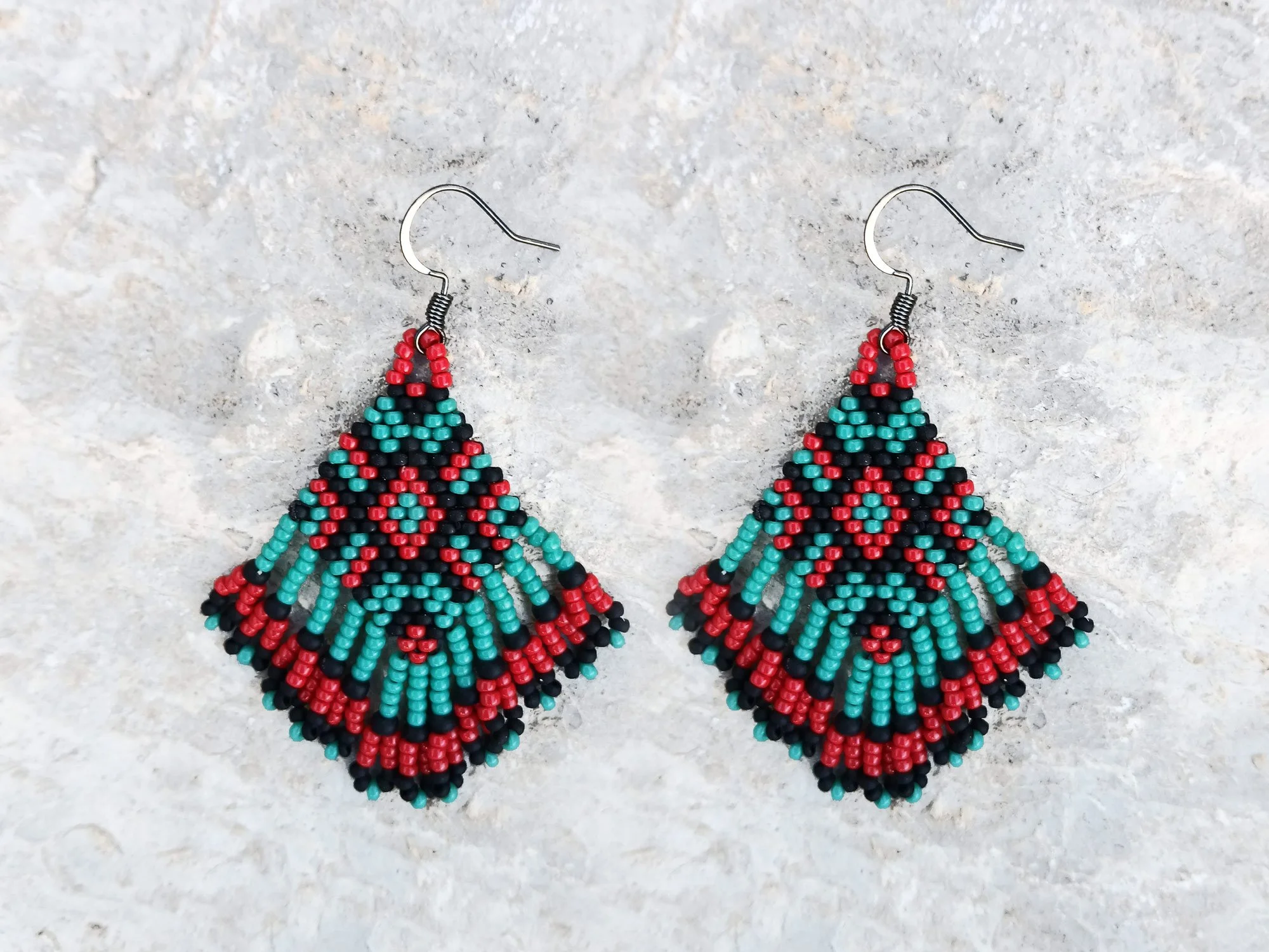 Handmade beaded fringe statement earrings handwoven in red, black, and turquoise with brick stitch in a Western boho style.