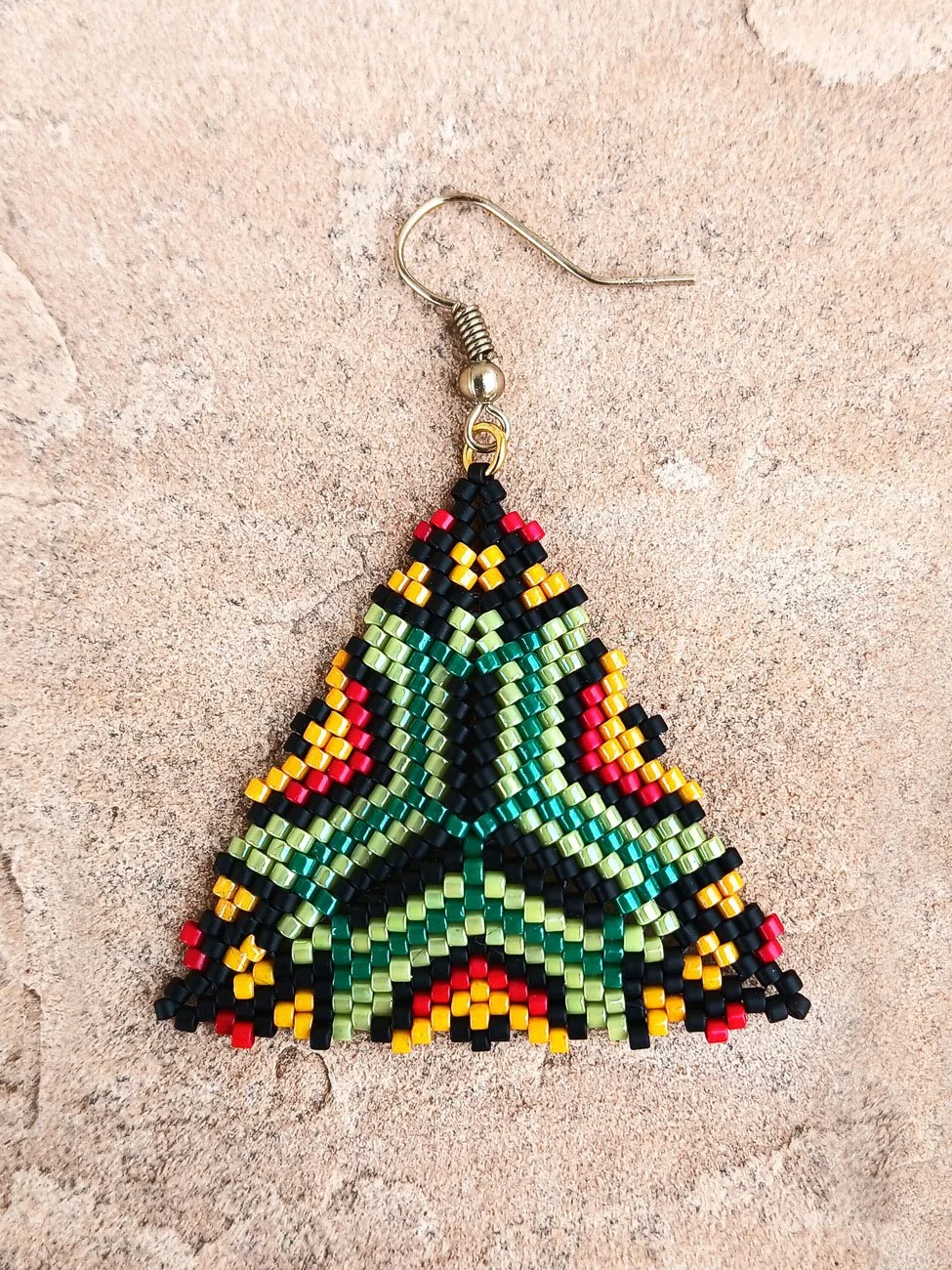 Handmade southwestern geometric triangle peyote beaded dangle earrings featuring a handwoven in green, red, black, and orange color palette.