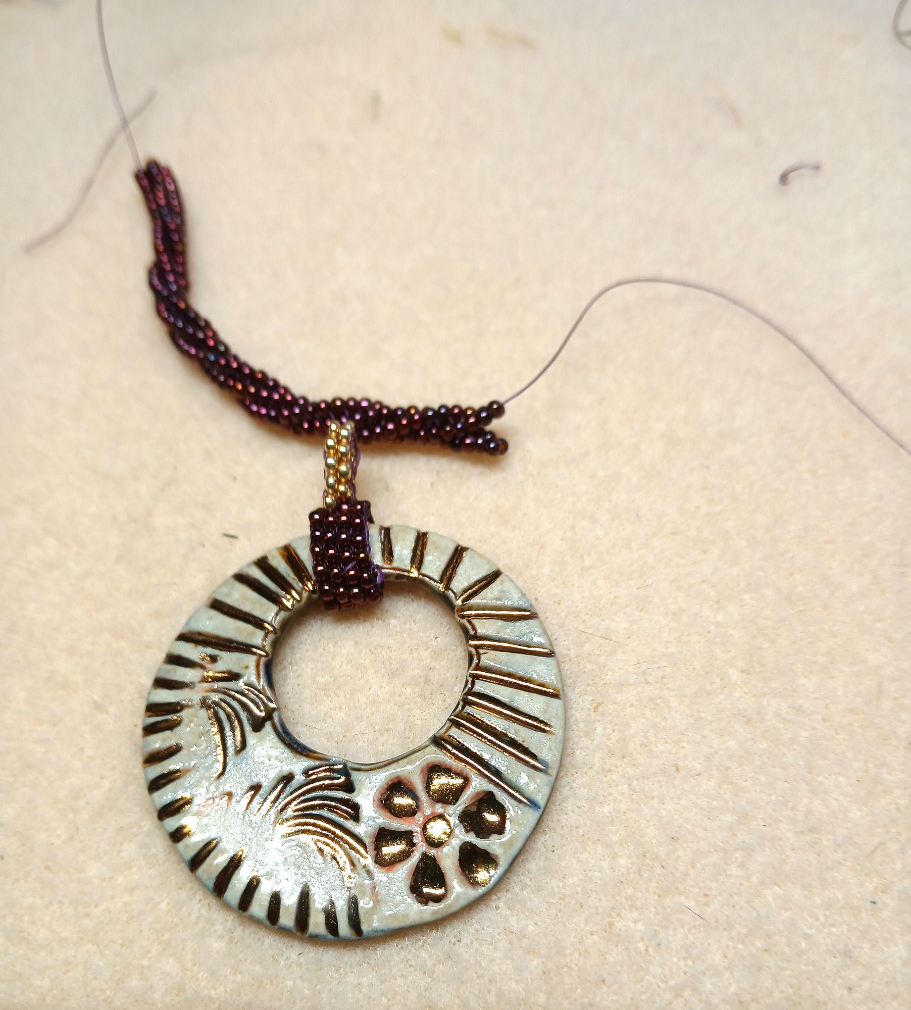 Hand-weaving an 8-row flat 2-column herringbone stitch transitioning into a twisted bead rope chain on a jewelry bench.