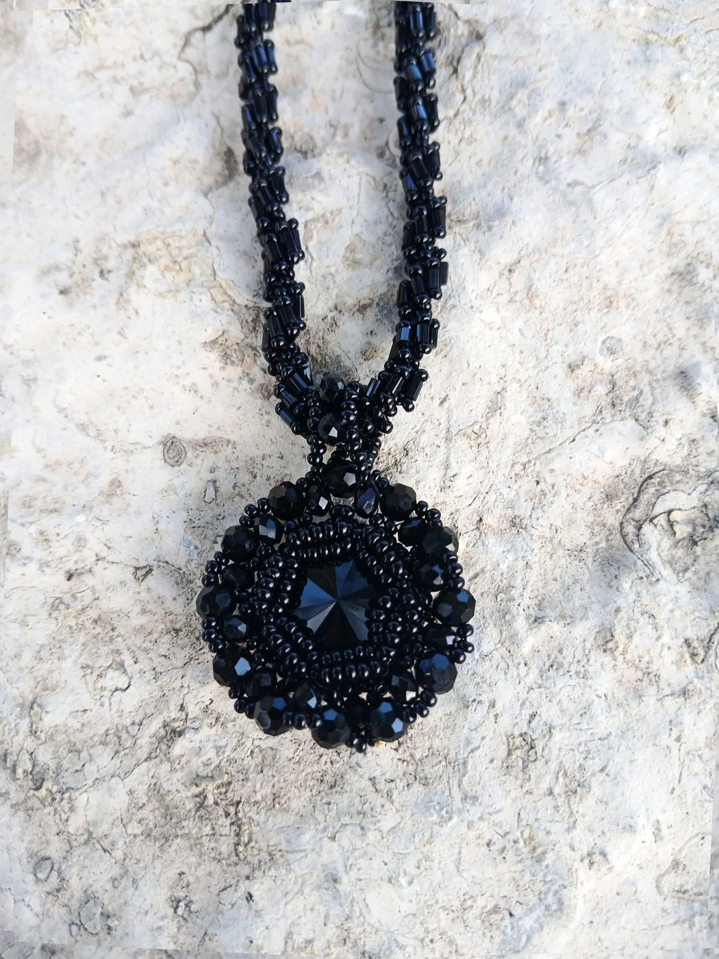 Handmade statement pendant necklace featuring a sparkling black Rivoli crystal focal point handwoven with a matching seed bead chain.