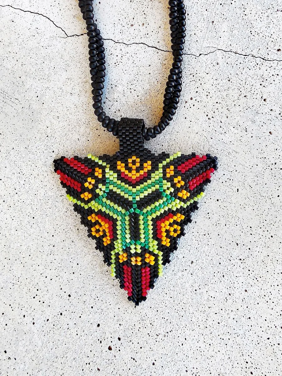 Handmade geometric triangle pendant necklace featuring handwoven herringbone and peyote stitch nonmetal beaded chain in black, green, yellow, and red.