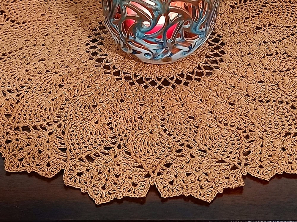 Exquisite and highly detailed 17-inch round crochet lace doily handwoven in a warm topaz color with a dimensional pineapple pattern