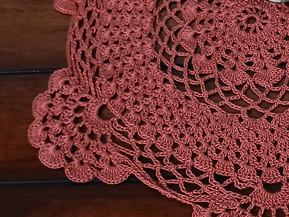 Handmade 13-inch round crochet lace doily in a rich rust orange color featuring intricate scalloped edges and pointed details