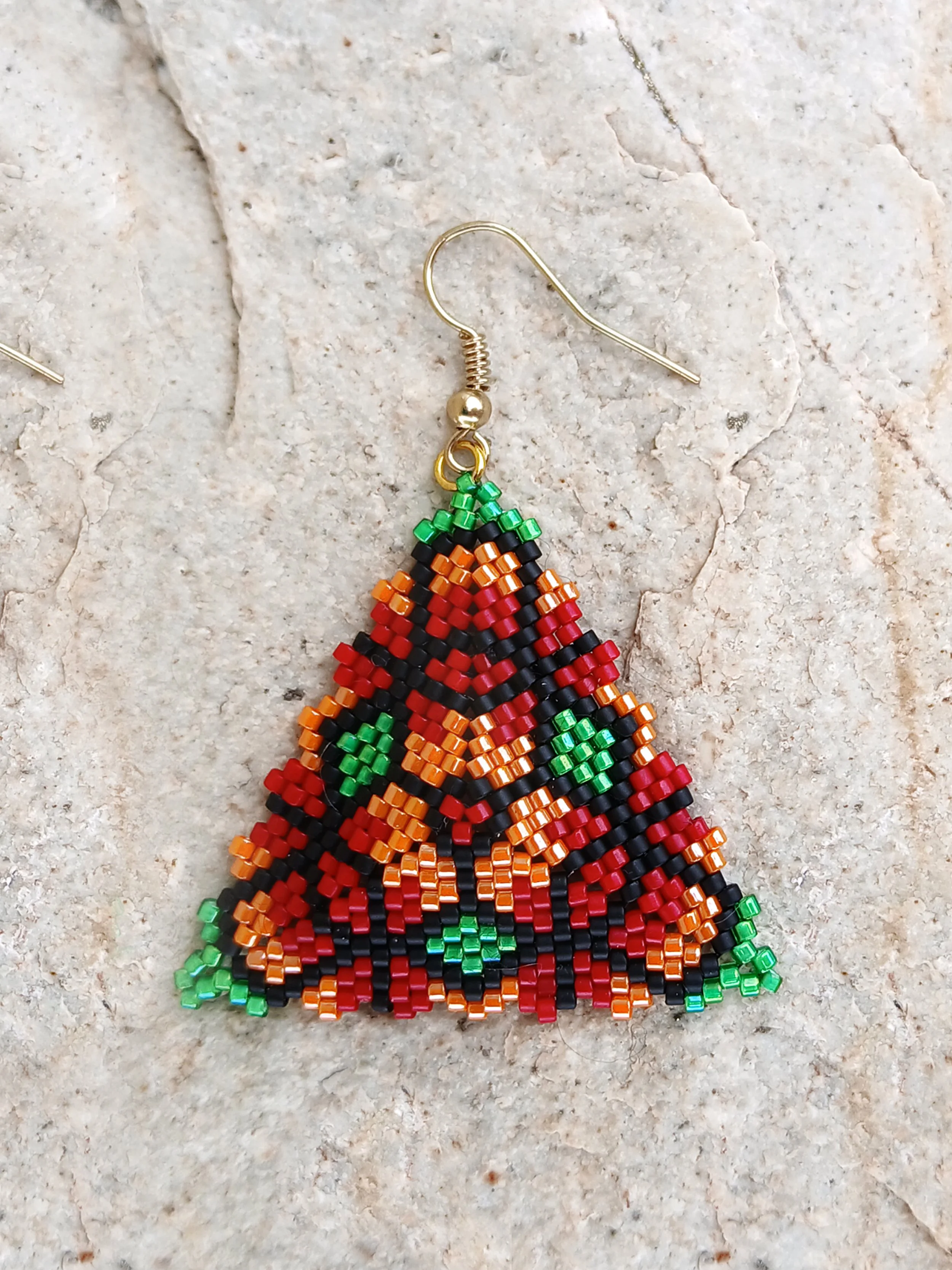 Handmade triangle peyote earrings with geometric floral pattern in red, green, orange, and black Miyuki Delica glass beads