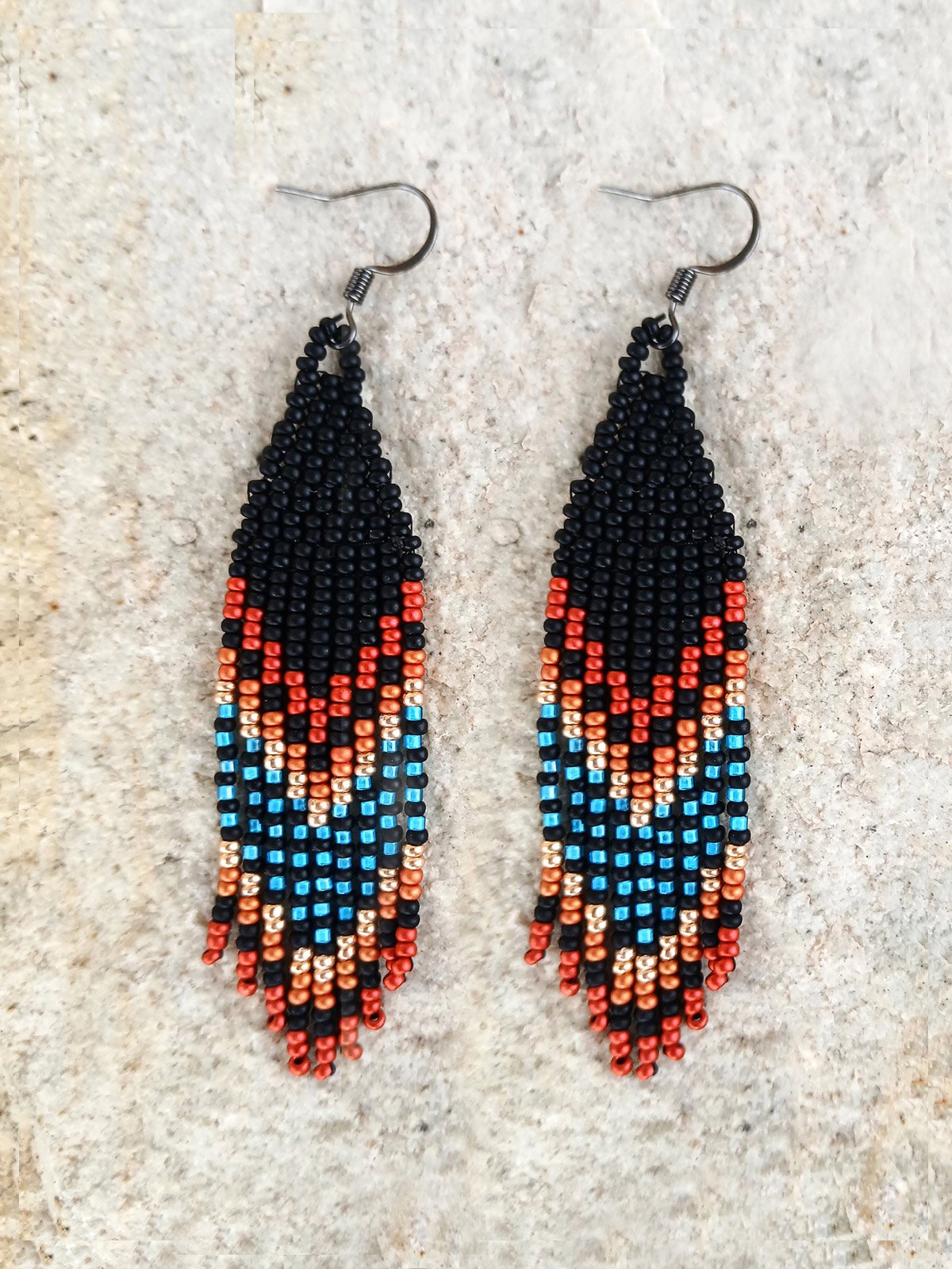 Handmade Southwestern beaded fringe dangle earrings handwoven in a rich black, red, blue, gold, and copper mountain sunset color palette.