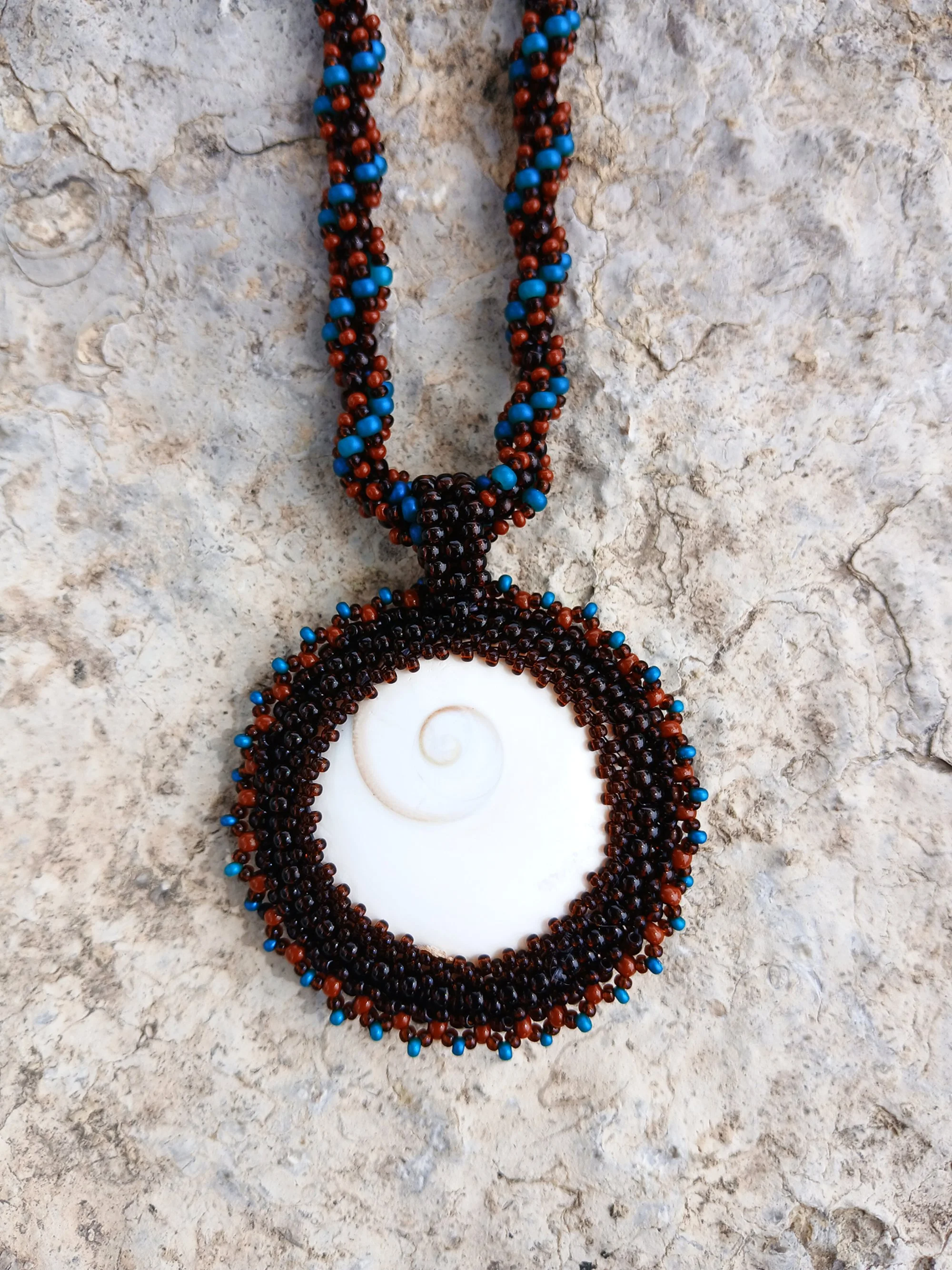 Handmade Boho-style necklace with natural spiral Shiva eye shell pendant on chain seed bead beaded blue brown black jewelry