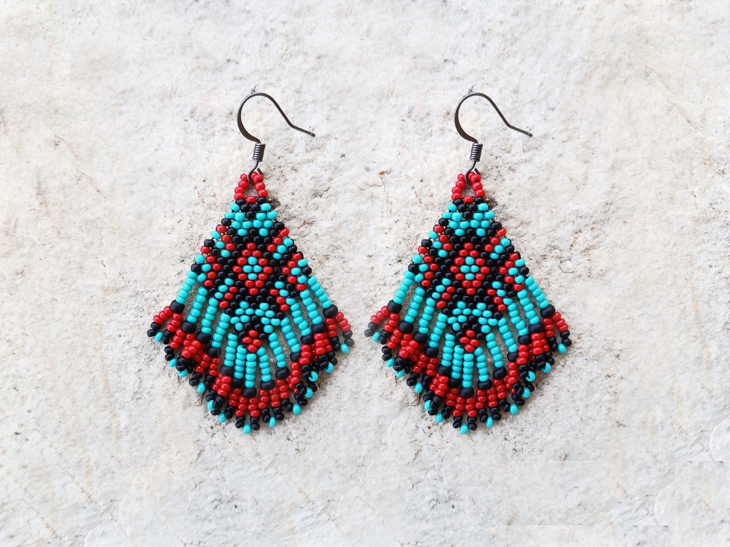 Handmade beaded fringe statement earrings handwoven in red, black, and turquoise with brick stitch in a Western boho style.