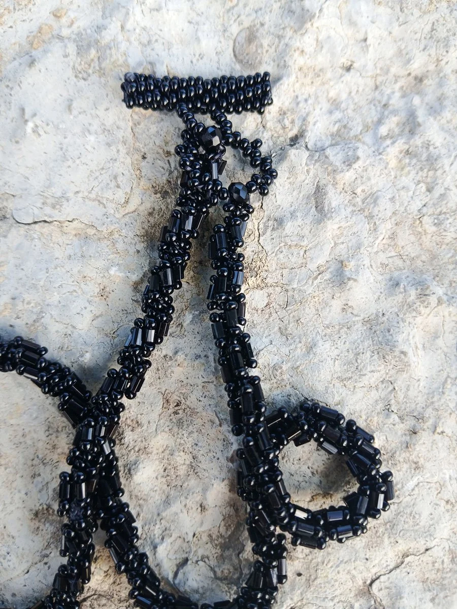 Handmade statement pendant necklace featuring a sparkling black Rivoli crystal focal point handwoven with a matching seed bead chain.