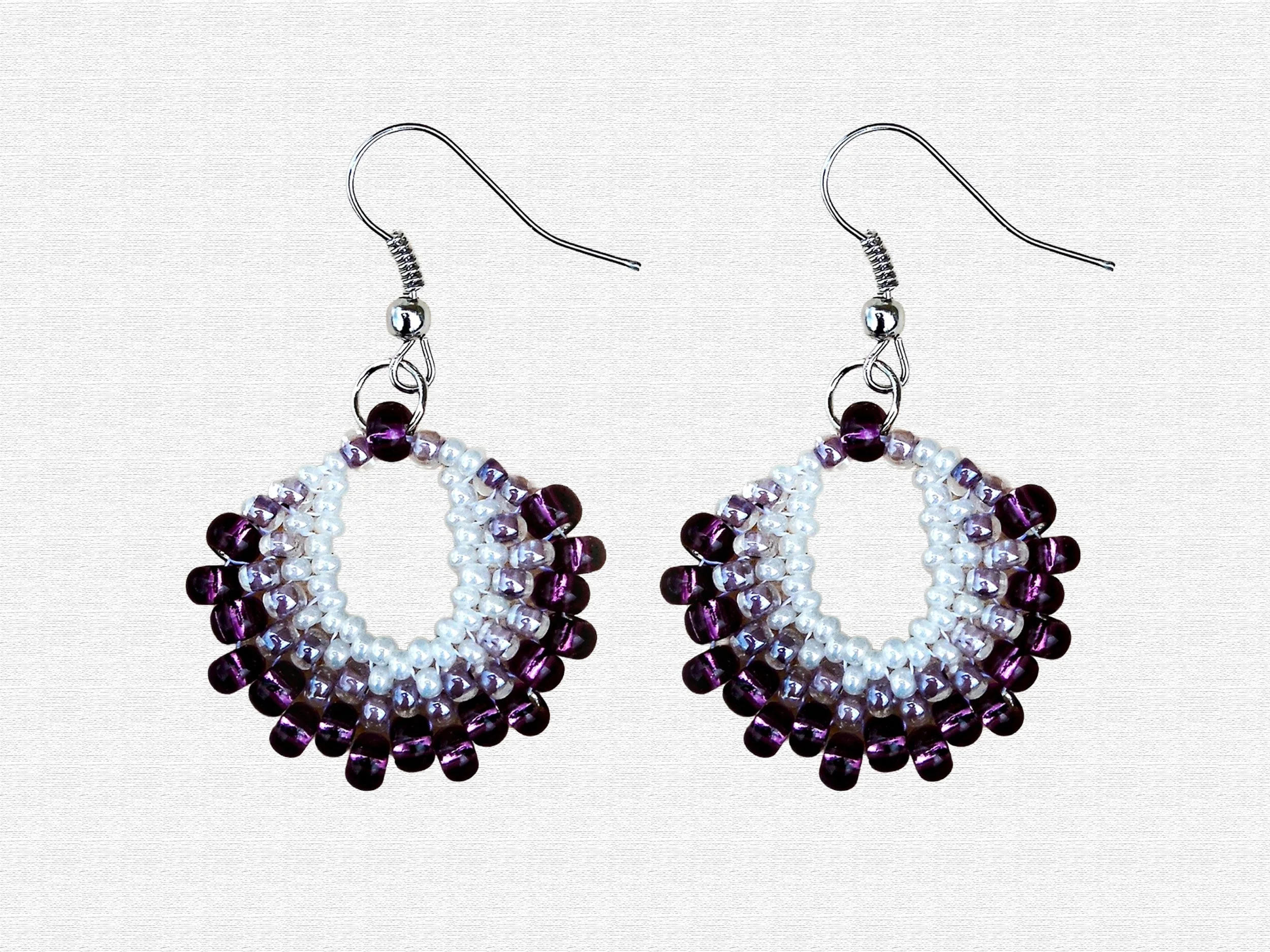 Handmade oval lightweight peyote stitch dangle earrings featuring a seed bead pattern in purple and white