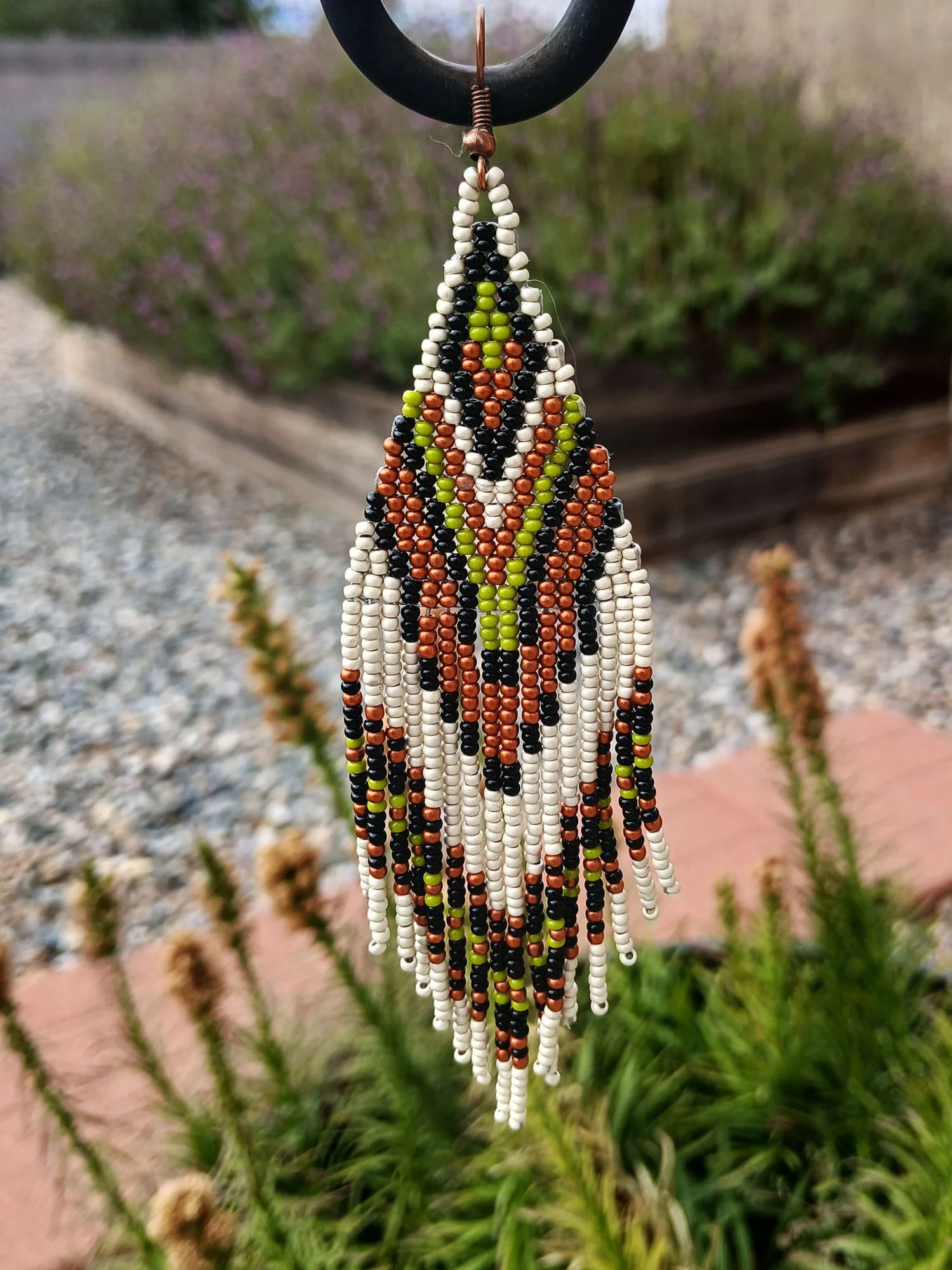 Handmade 5” beaded fringe earrings handwoven in chevron brick stitch with earthy green, matte silver, black, and copper.