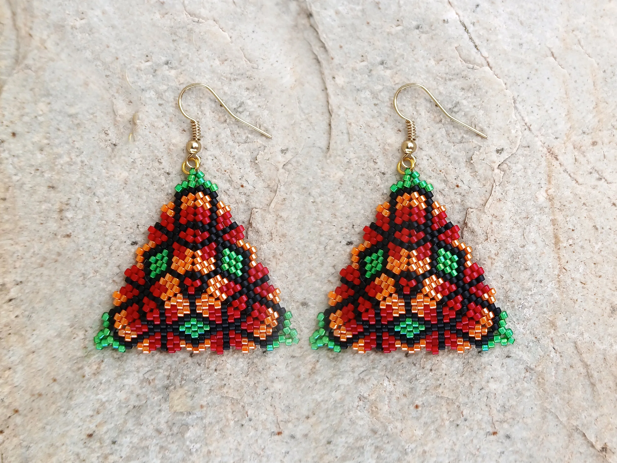 Handmade triangle peyote earrings with geometric floral pattern in red, green, orange, and black Miyuki Delica glass beads