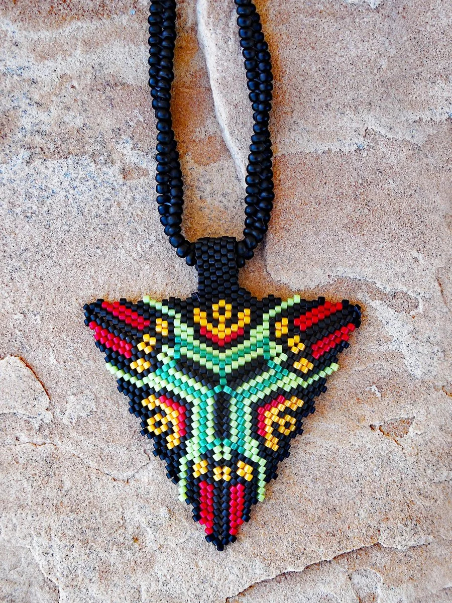 Handmade geometric triangle pendant necklace featuring handwoven herringbone and peyote stitch nonmetal beaded chain in black, green, yellow, and red.