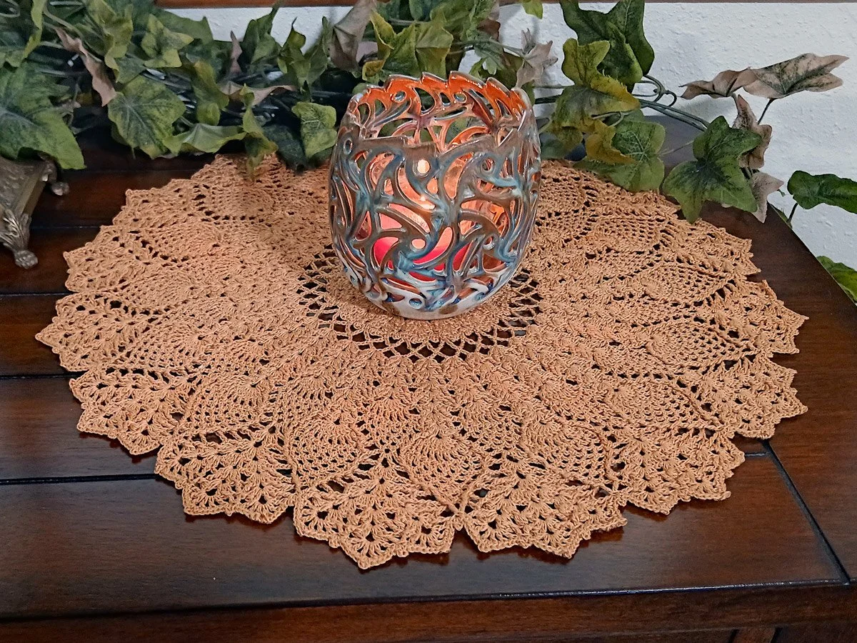 Exquisite and highly detailed 17-inch round crochet lace doily handwoven in a warm topaz color with a dimensional pineapple pattern