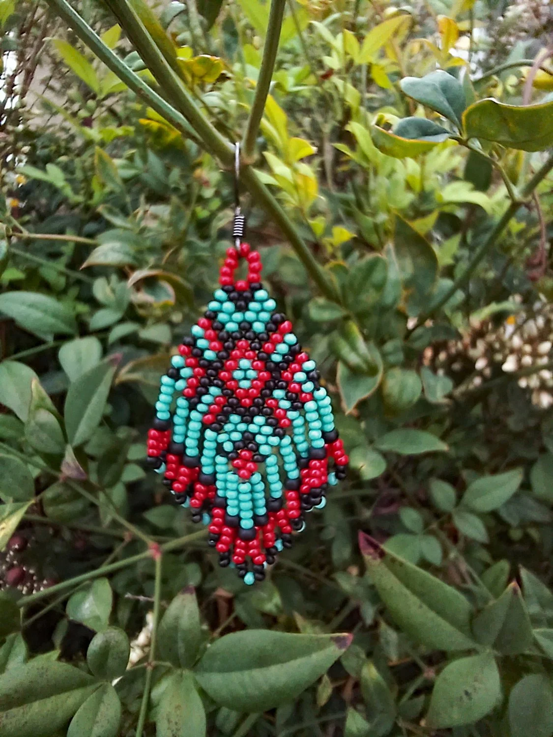 Handmade beaded fringe statement earrings handwoven in red, black, and turquoise with brick stitch in a Western boho style.