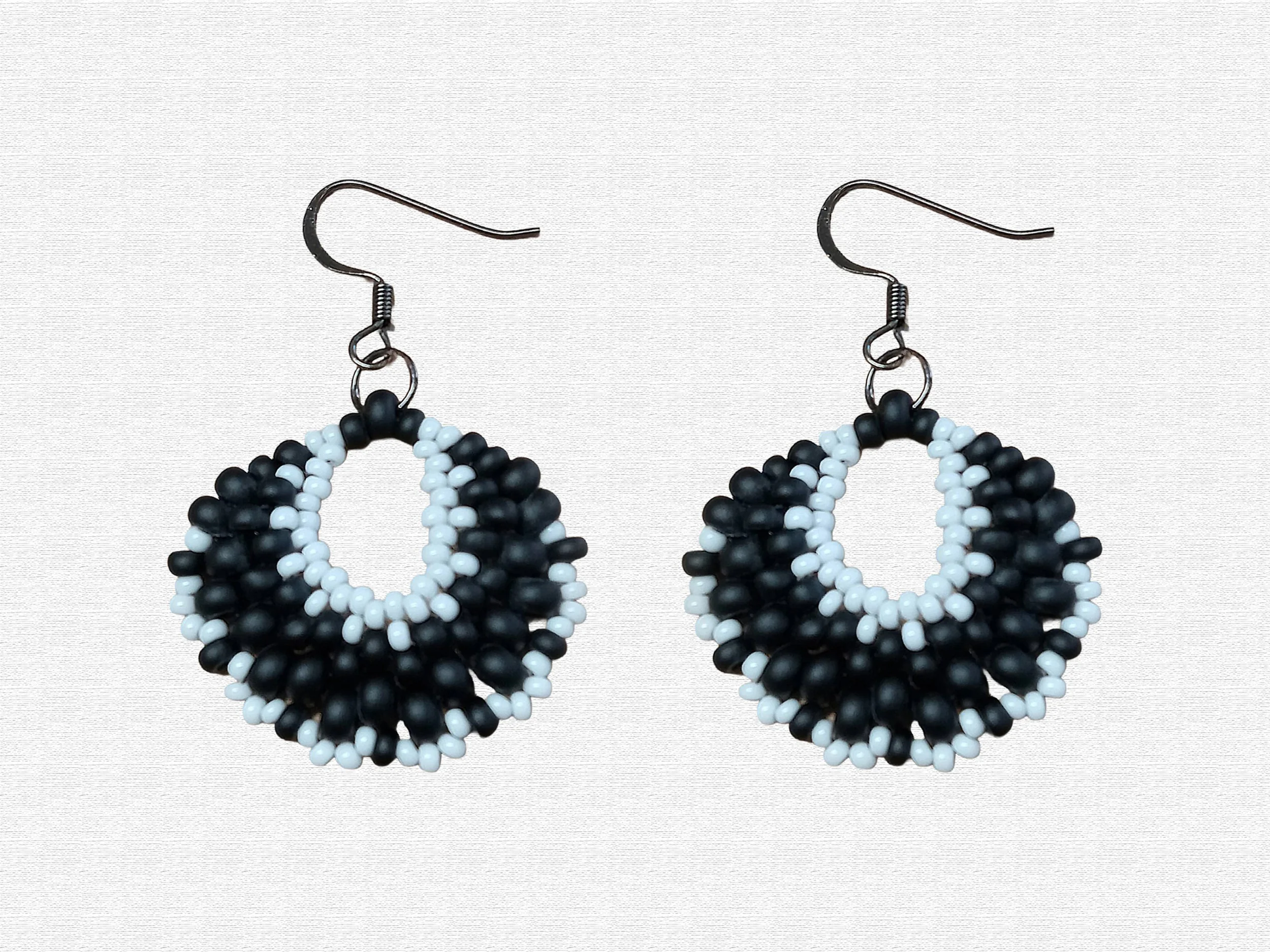 Handmade oval lightweight peyote stitch dangle earrings featuring a seed bead pattern in Black and White