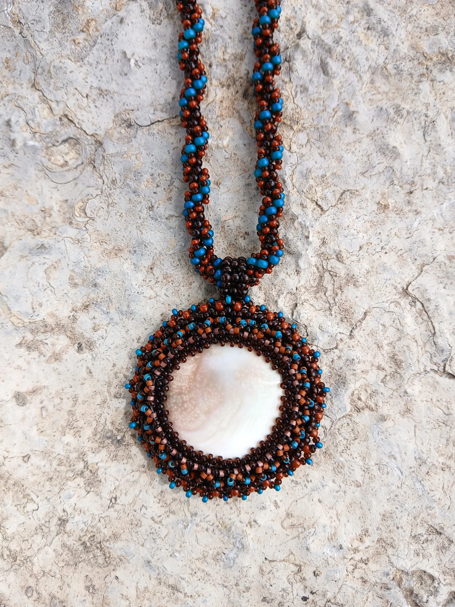 Handmade Boho-style necklace with natural spiral Shiva eye shell pendant on chain seed bead beaded blue brown black jewelry