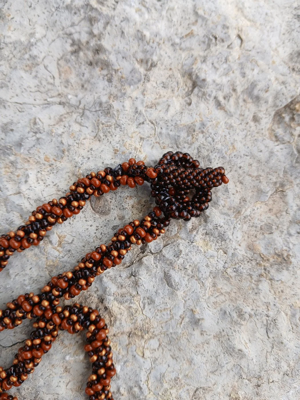 Handmade nature-inspired beaded necklace featuring a close-up on non-metal beaded chain handwoven in brown and rust seed beads.
