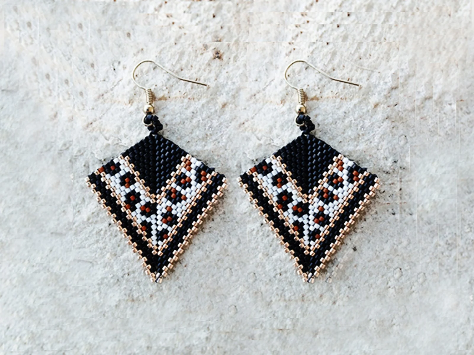 Handmade geometric arrow-shaped beaded earrings in peyote stitch and handwoven in a chic animal print jaguar pattern with metallic gold accents.