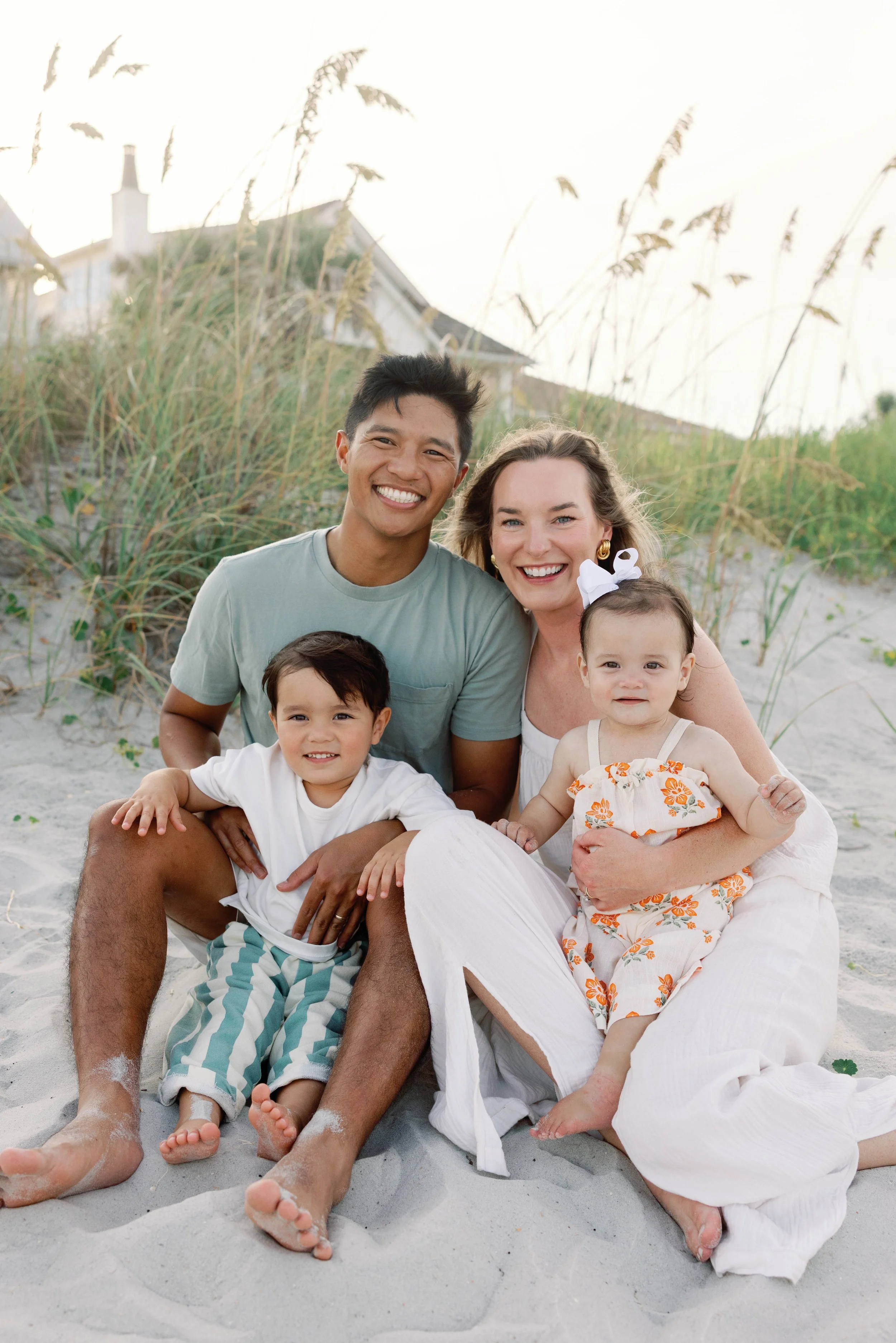 Dr. Noah Andone and his family sitting together on a Jacksonville beach, the inspiration behind returning home to open Swell Smiles