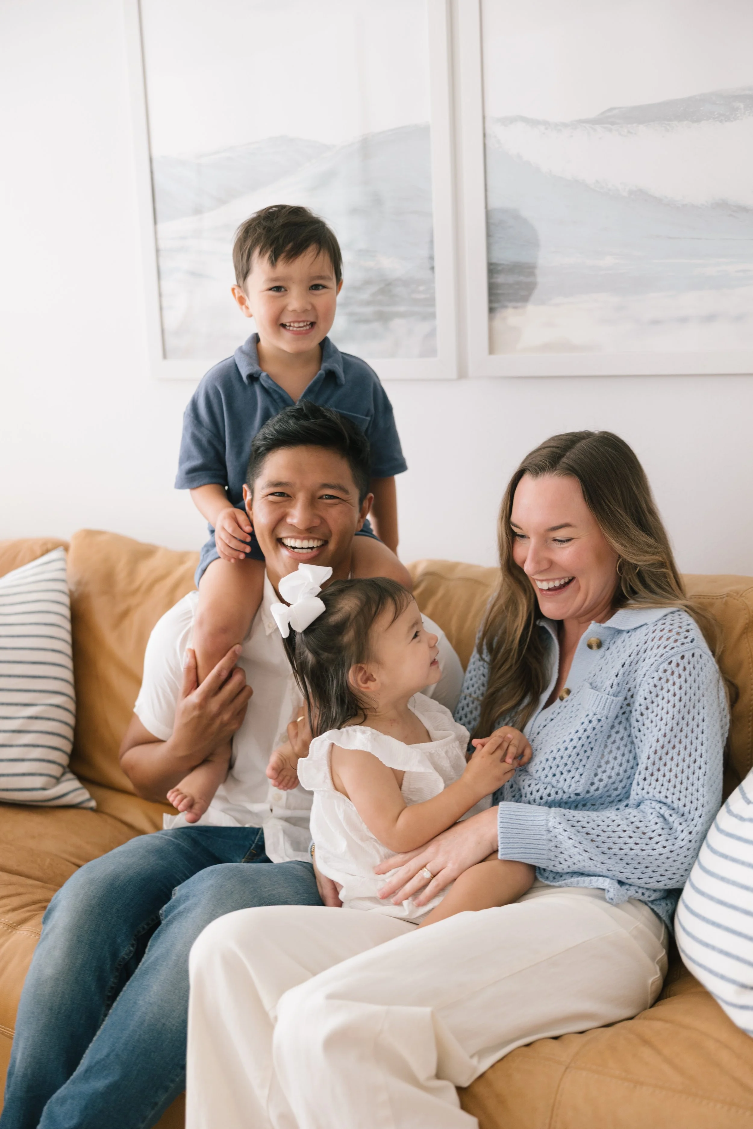Dr. Noah Andone with his wife Rory and their two children, laughing together at home in Jacksonville
