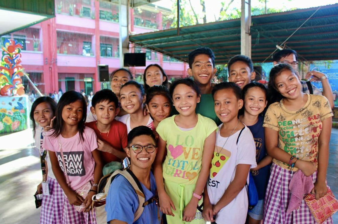 Young Dr. Noah Andone smiling with children during a dental mission trip, the experience that inspired him to specialize in pediatric dentistry