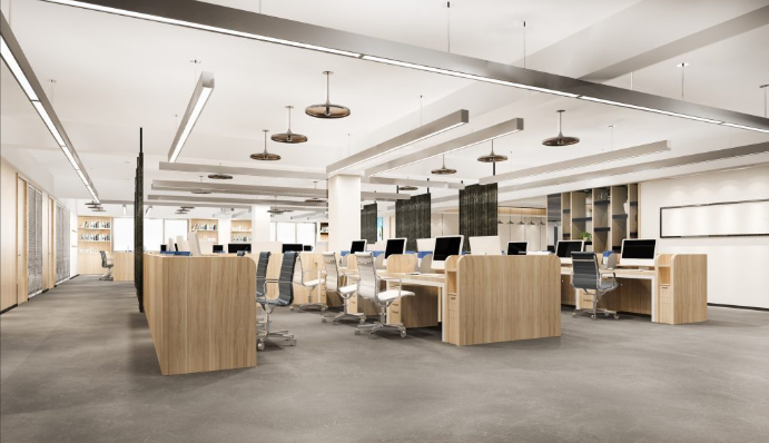 Modern open-plan office with wooden desks, white office chairs, and multiple desktop computers, illuminated by linear ceiling lights.