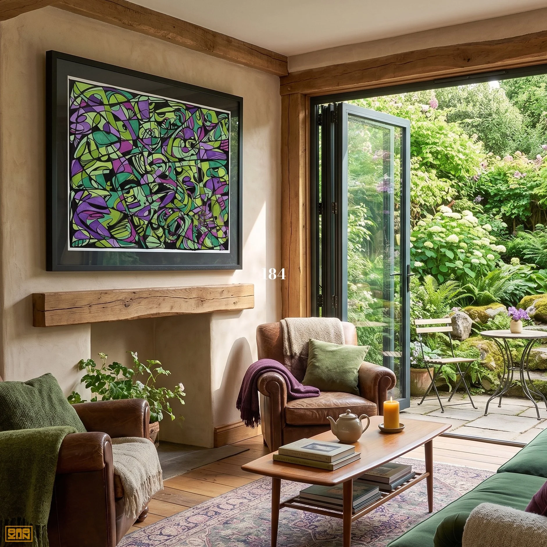 Living room with leather armchairs, green and beige cushions, wooden coffee table with books, abstract painting on beige wall, open sliding glass door revealing lush garden with flowers and green foliage, and a small outdoor table with chairs.