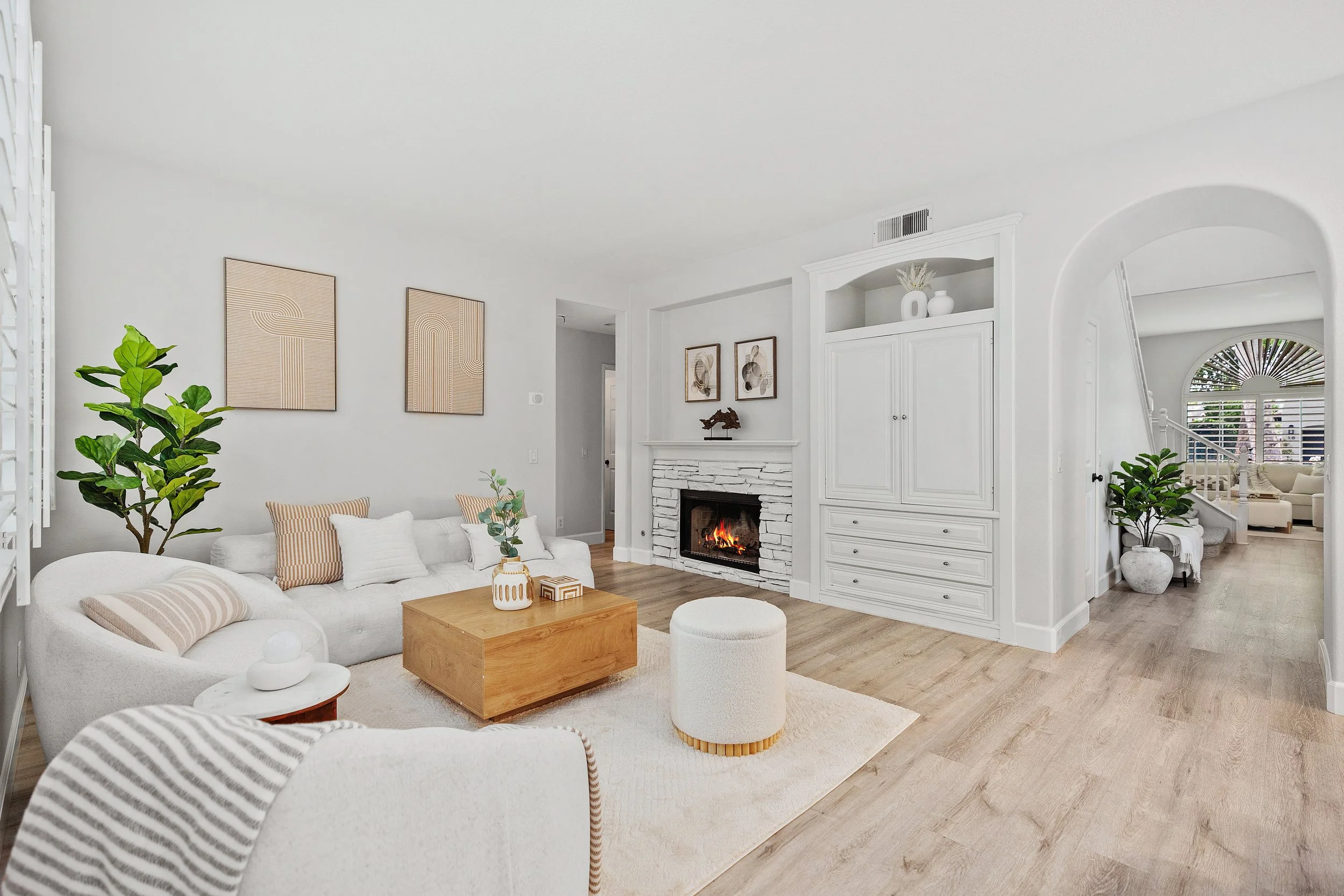 Orange County luxury staged living room with neutral decor, fireplace, and light wood floors