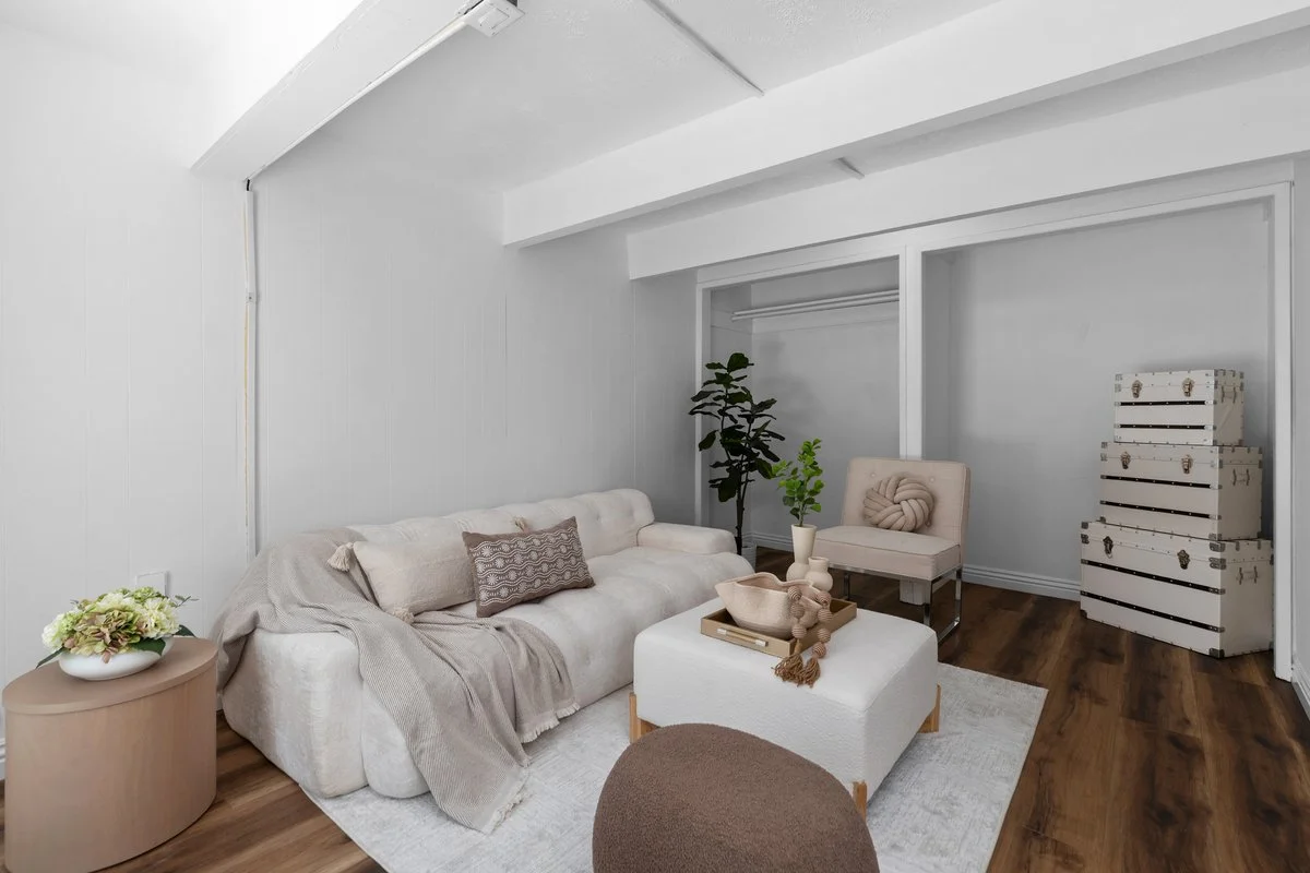 The pool house is a separate room off the garage, original to the house. A sofa, an ottoman and one chair are enough to show it as usable space, which is the entire point of staging a room most sellers leave empty.