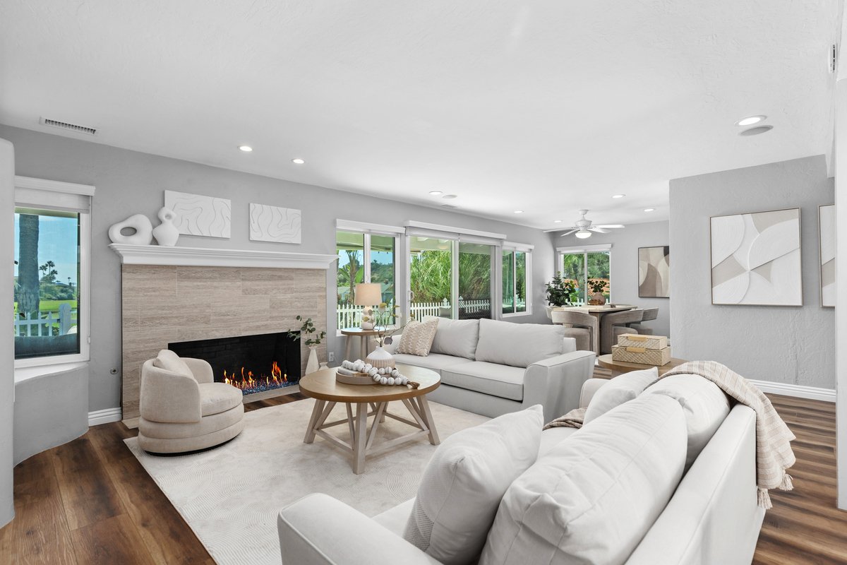 The house came to us completely empty, so every piece in it is ours. A low sectional wraps the corner and two swivel chairs close the circle at the hearth, with all of the seating kept below the window line on both walls so the light stays part of th