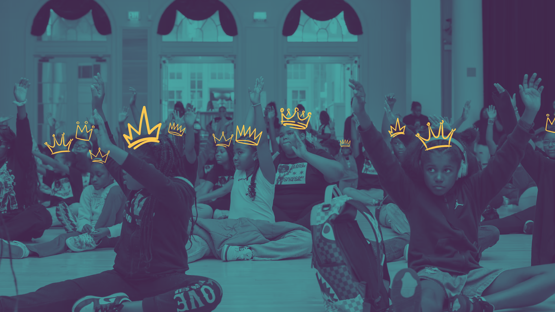 Children sitting on the floor in a large, ornate room with stained glass windows, raising their hands, with digital crown illustrations over their heads.