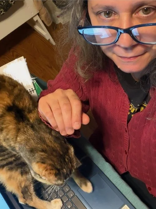 Artist with cat on her computer keyboard