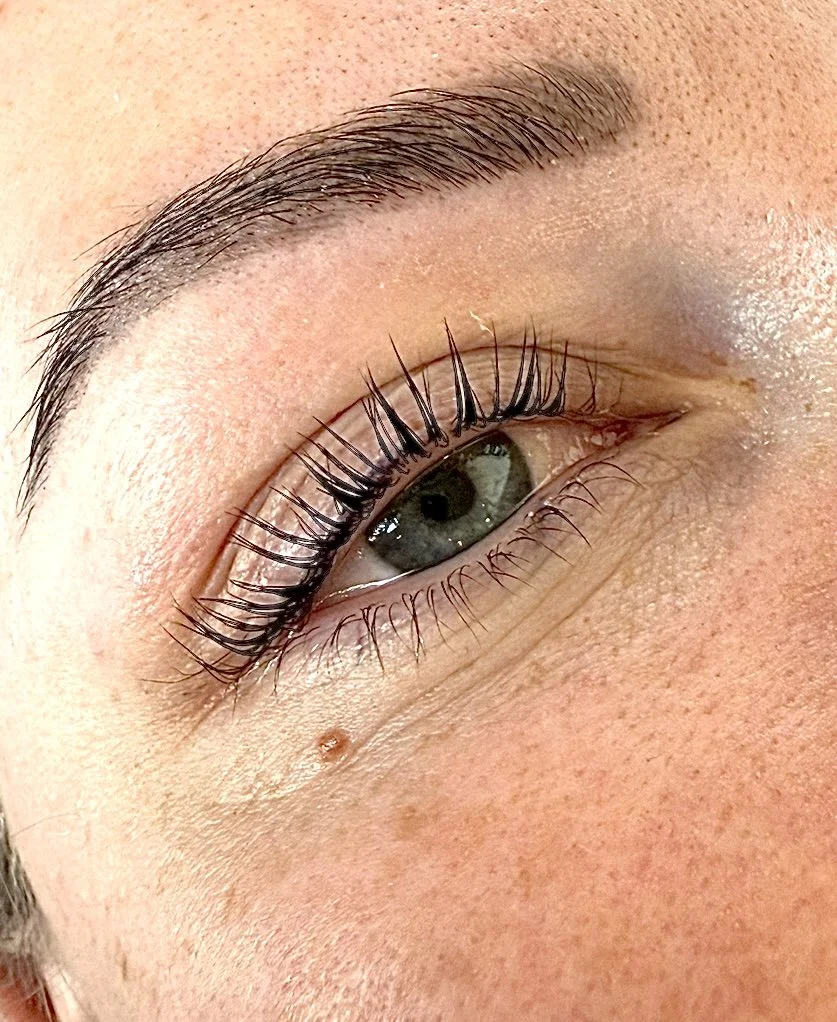 Close-up of a human eye with makeup and detailed skin texture.