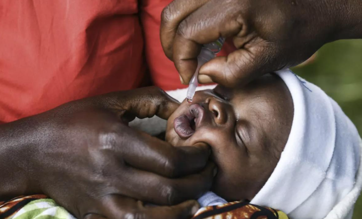 Child receiving oral medication with a dropper from an adult.