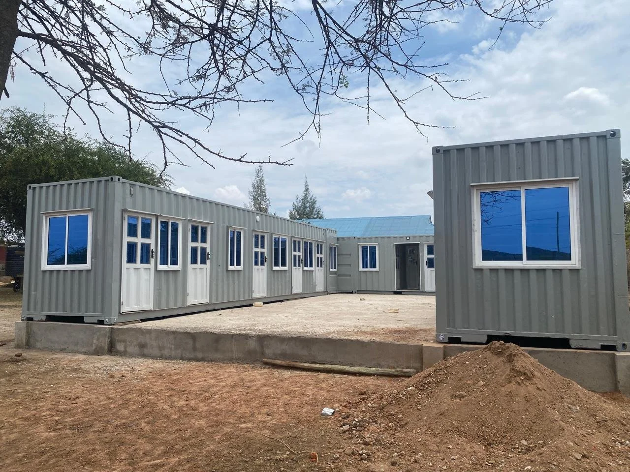 Three shipping containers assembled in a U-shape on a foundation.