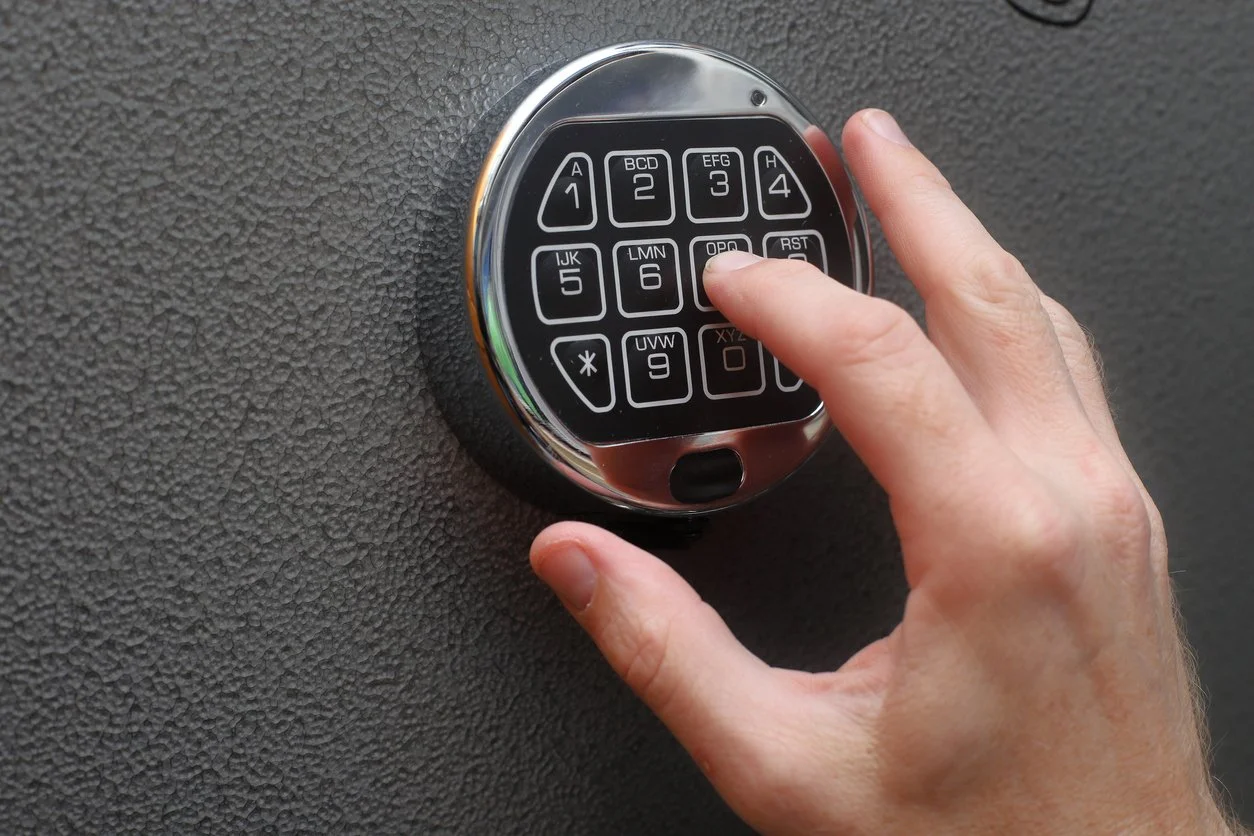 Proper firearm storage - A man locking his firearms in a safe.