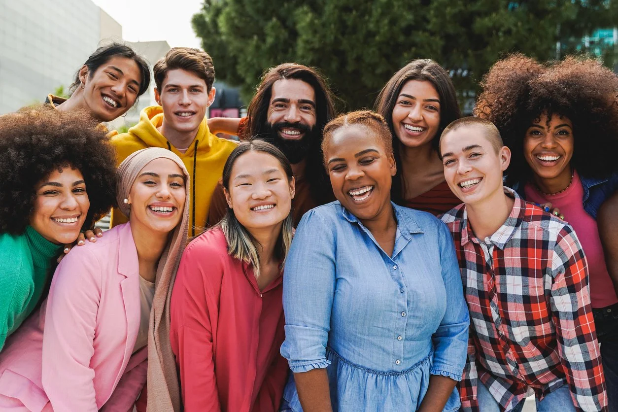 Navigating immigration and assimilation - A diverse group of happy immigrants posing for a photo.