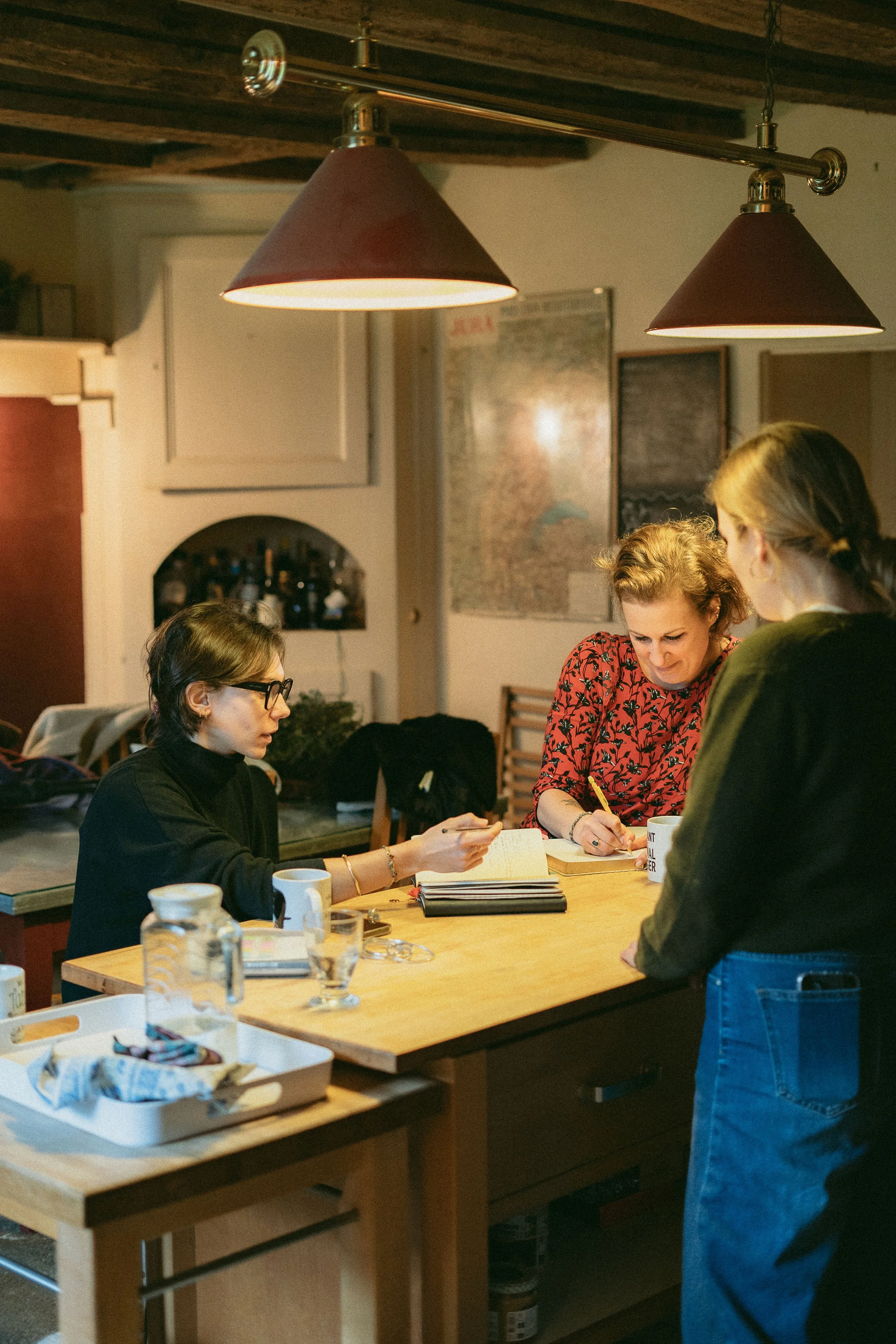 Mathilde Nicod et ses clientes qui discutent ensemble de l'identité qu'elle leur crée à Besançon pour leur gîte