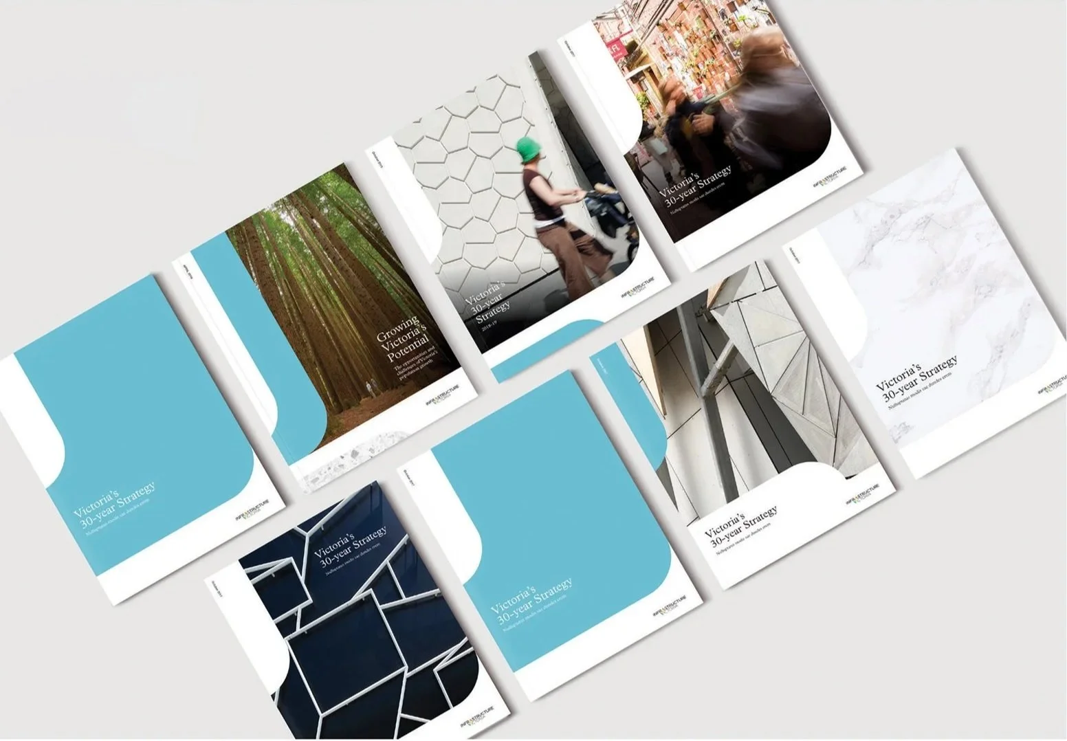 Several brochures titled 'Victoria's 30-year Strategy' laid out on a flat surface, with images of forests, city streets, architectural structures, and abstract designs on their covers.