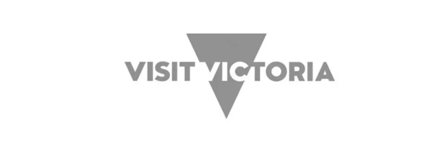 Visit Victoria logo featuring a stylized downward-pointing triangle with a smaller triangle above and text 'VISIT VICTORIA'.