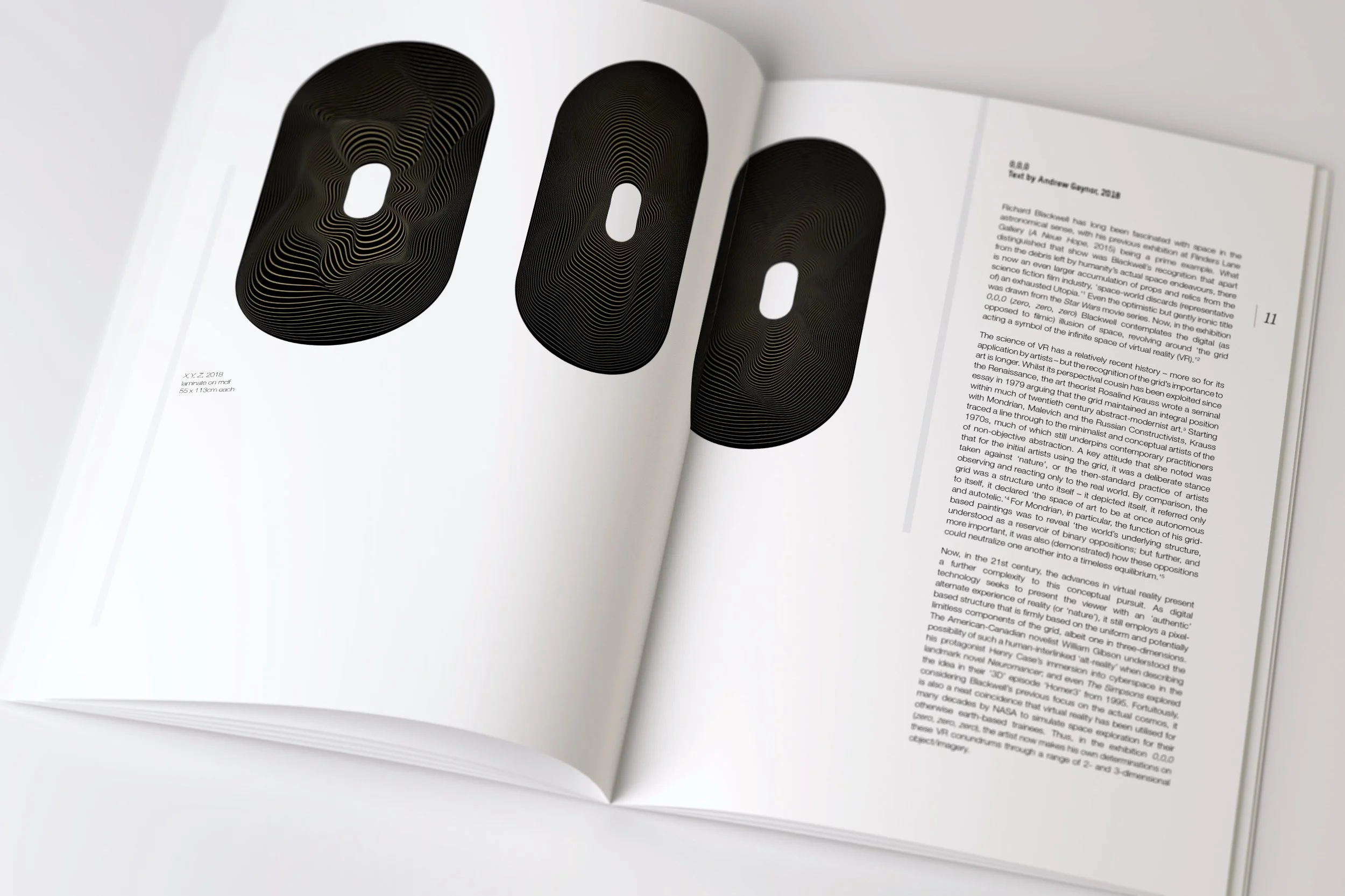 Open magazine displaying a black and gold digital artwork of the number 00 and a page of text.