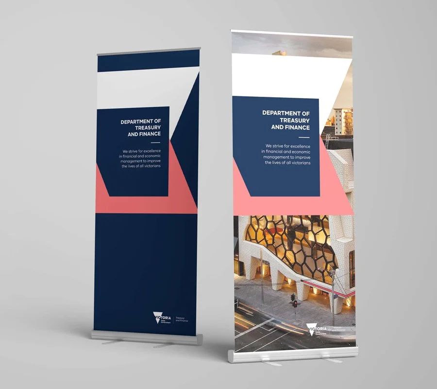 Two vertical banner stands displaying the Department of Treasury and Finance logo and message, with one featuring the outside of the Melbourne Recital Centre.