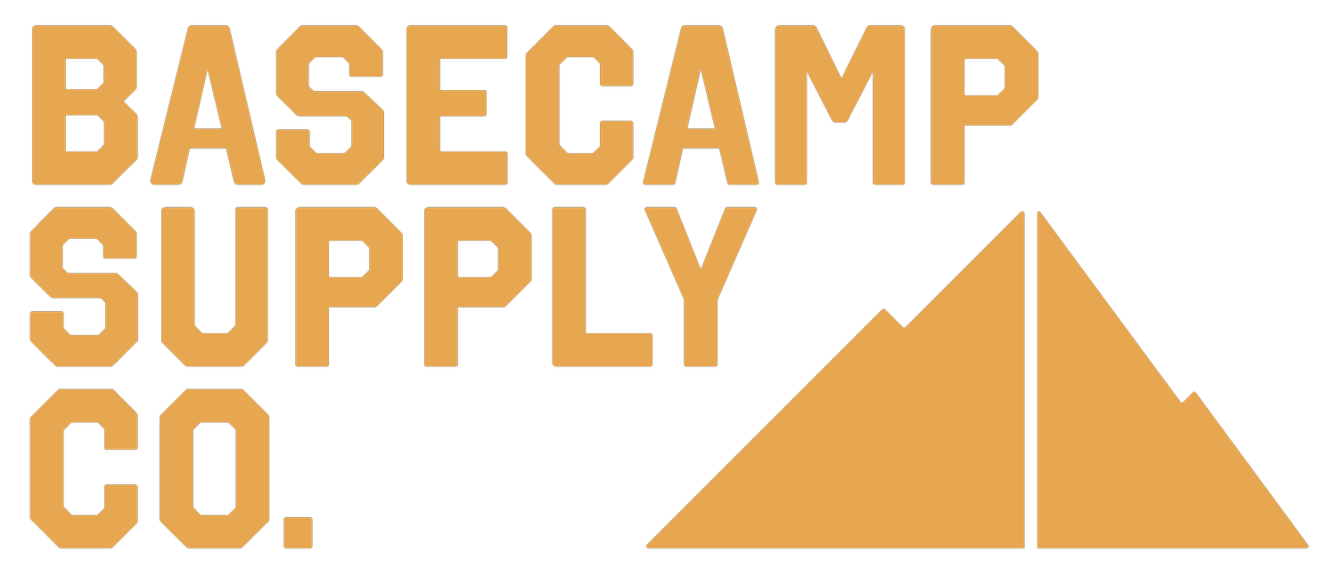 Logo for Basecamp Supply Co. featuring stylized text and a mountain graphic in orange and black.