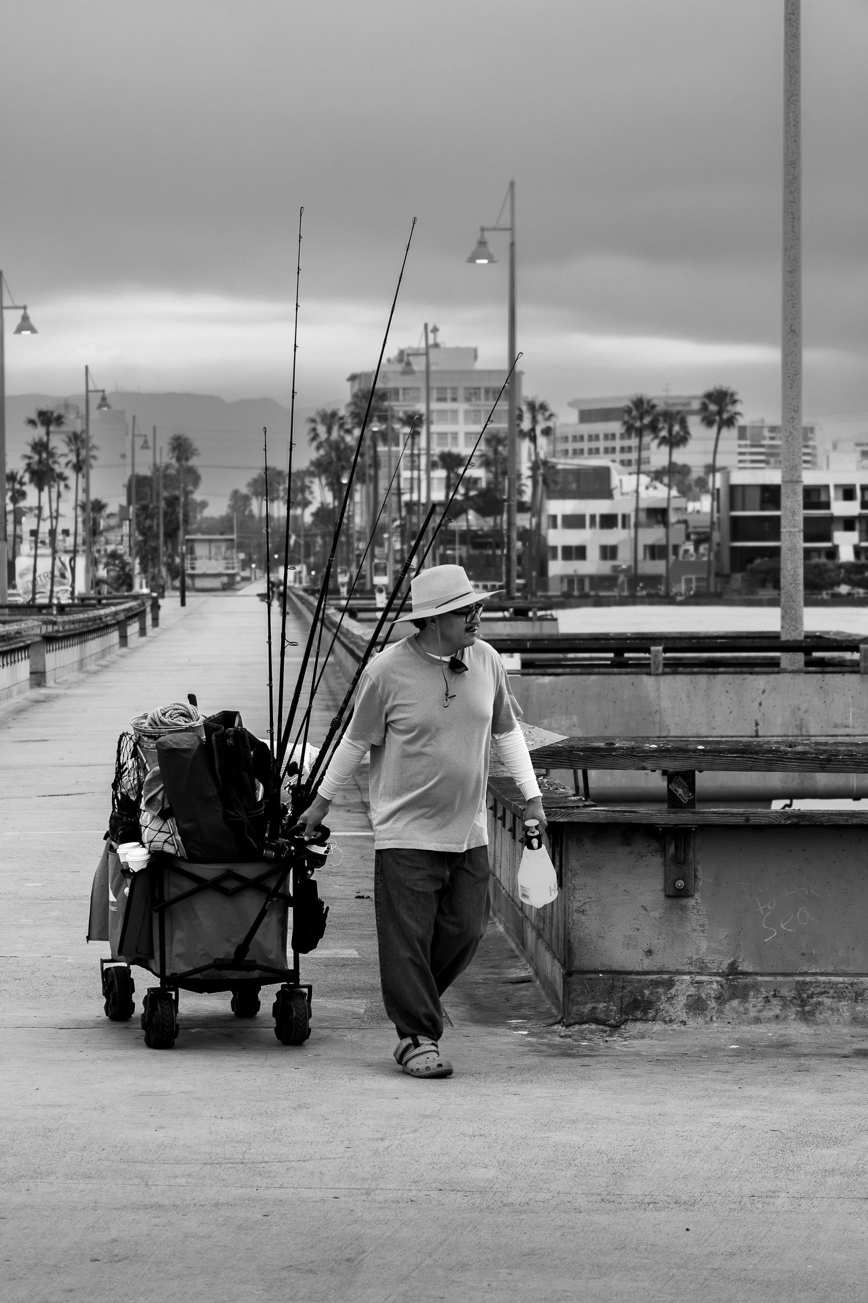 man fishing on venice beach pier